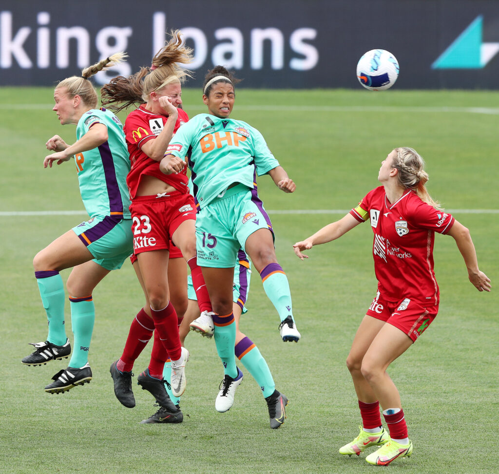 Cyera Hintzen leaps between Adelaide United's Fiona Worts and Matilda McNamara on New Year's Day. Photo: Sarah Reed/Getty Images, supplied by Perth Glory FC.