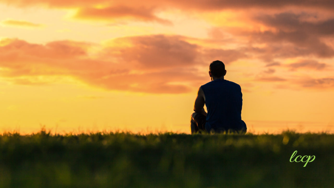 a person sitting outside alone practicing mindfulness