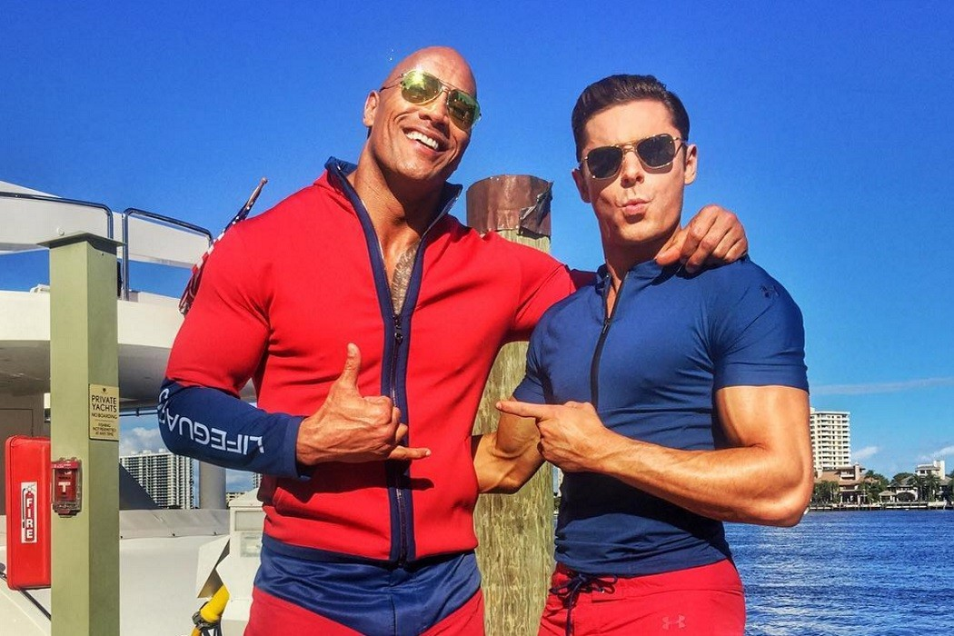 The Rock and Zac Efron wearing sunglasses while on the set of Baywatch 