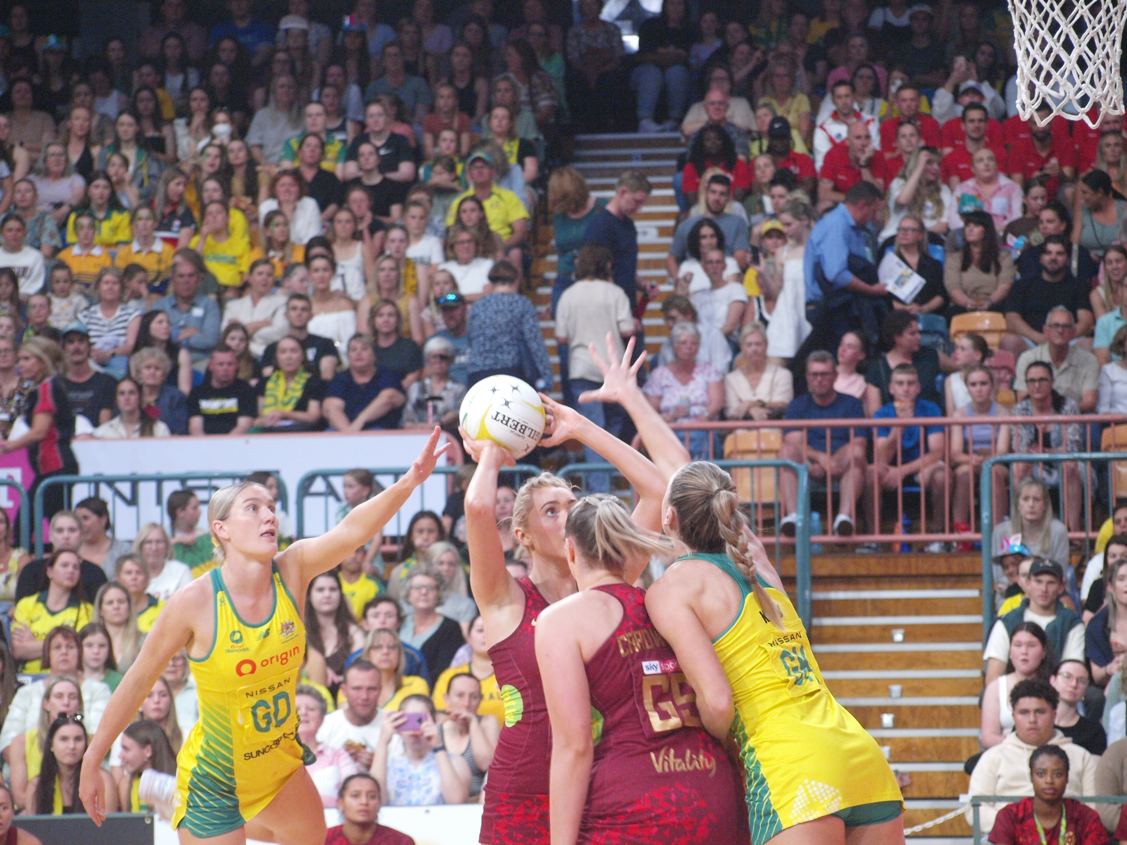 Helen Housby shoots under the pressure of Courtney Bruce (L) and Sarah Klau