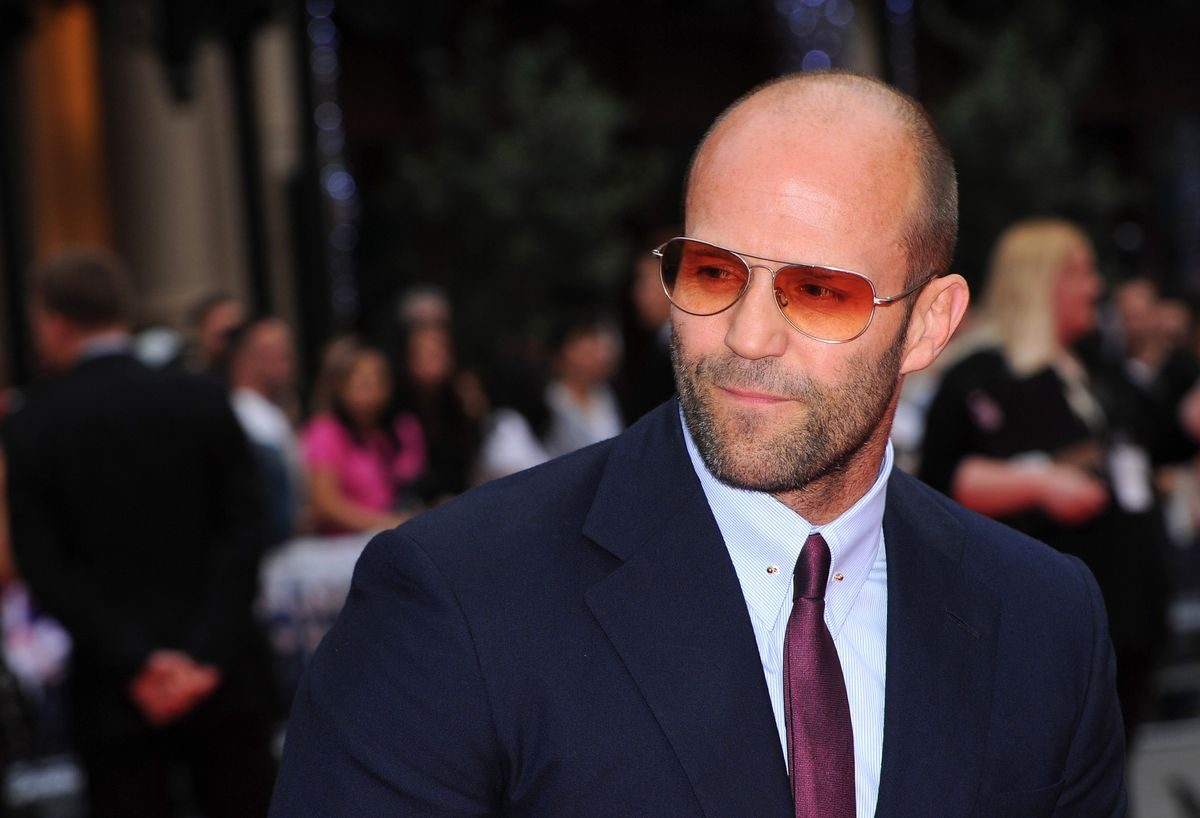 Jason Statham wearing sunglasses and a suit with tie