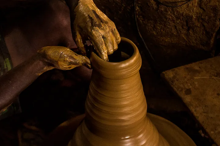 A man throwing clay on a wheel