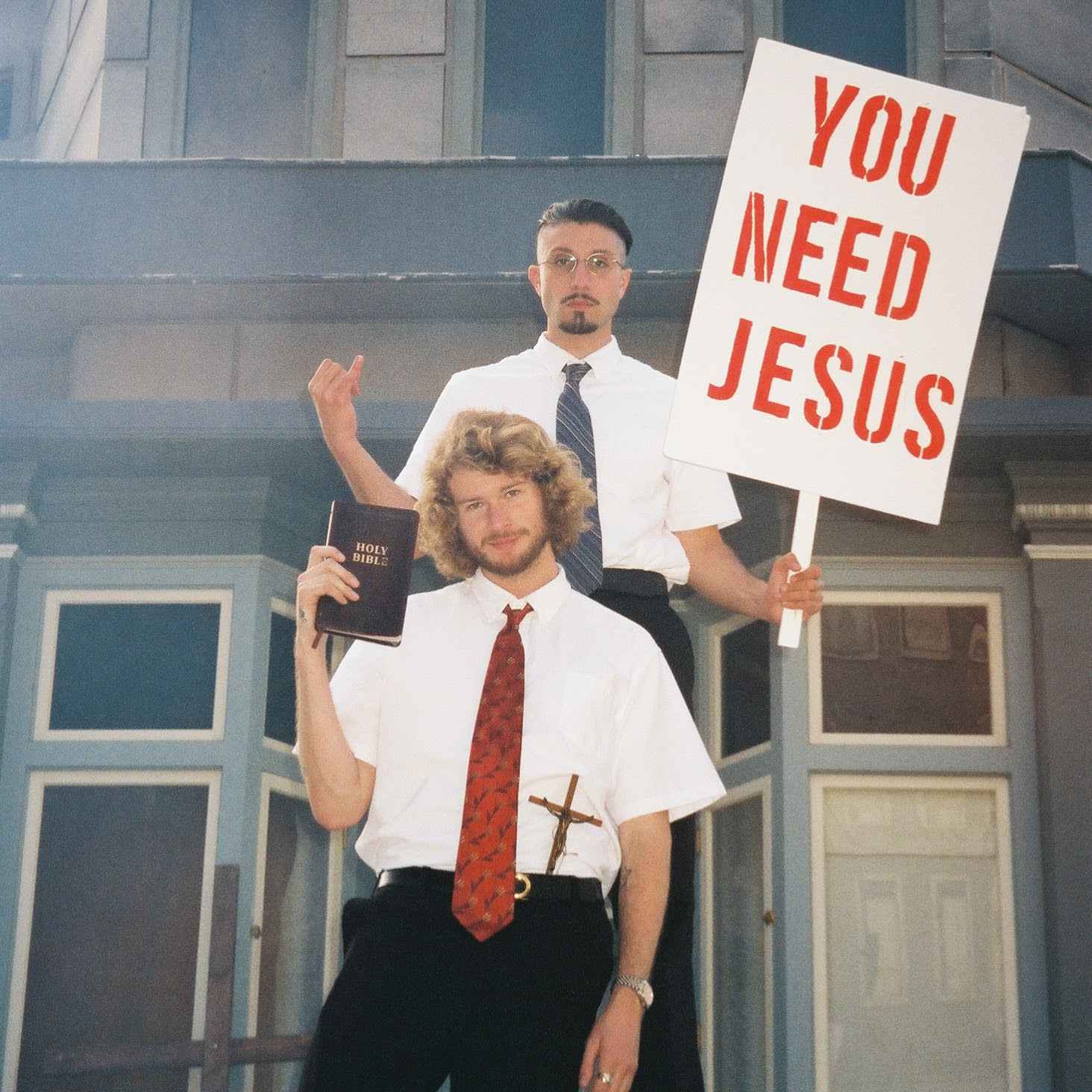 Yung Gravy (front) and bbno$ (back) holding a Holy Bible and a white picket-fence that says "You Need Jesus", respectively, for their 'You Need Jesus' single cover