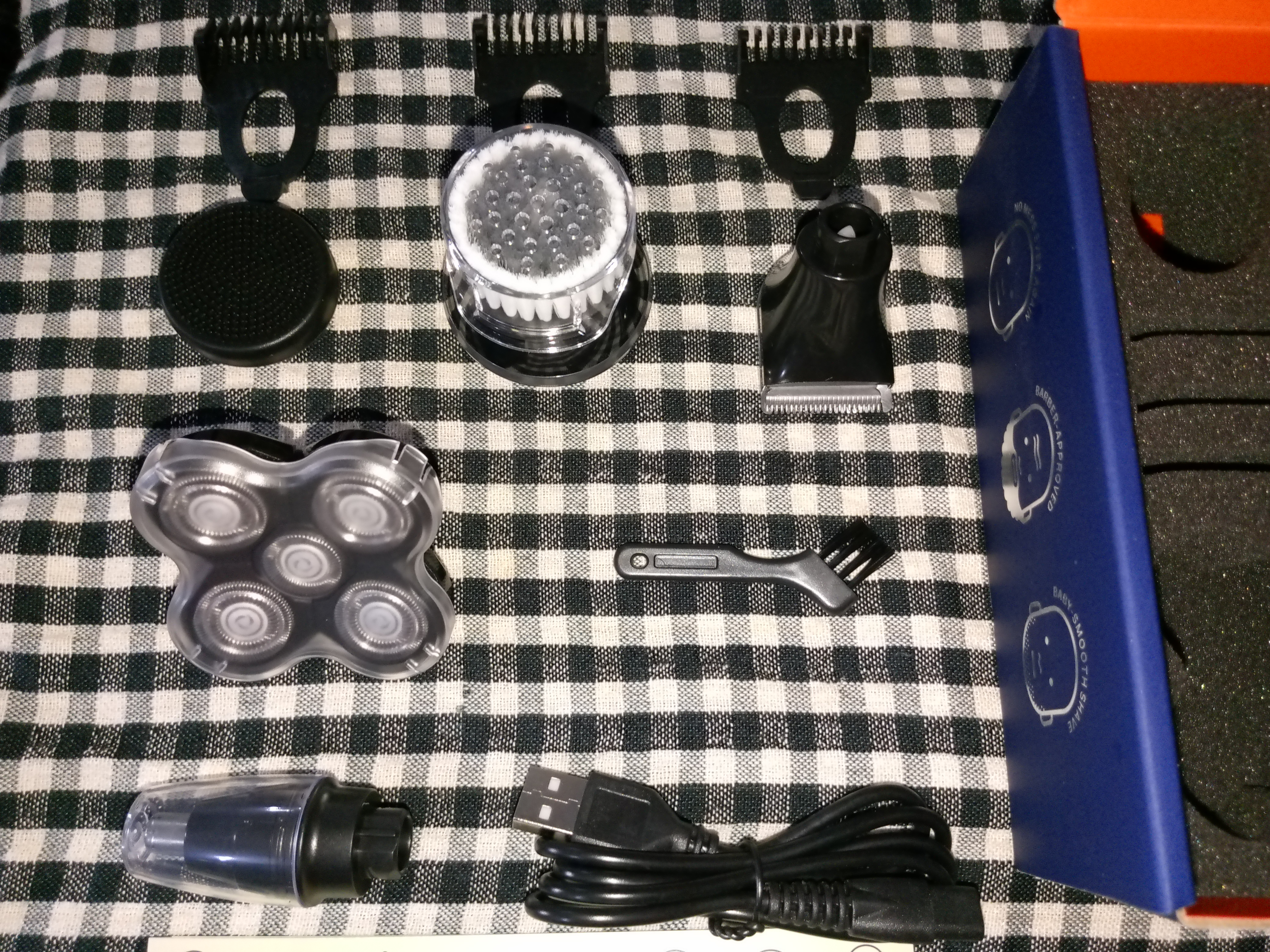 Multiple attachments of a rotary head shaver spread out on a table