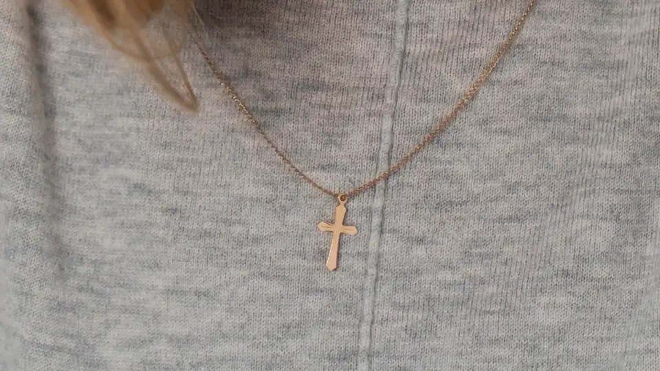 Millennial woman wearing a rose gold cross necklace from Glor-e