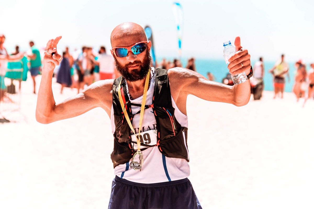 bald male runner wearing sunglasses while participating in a marathon