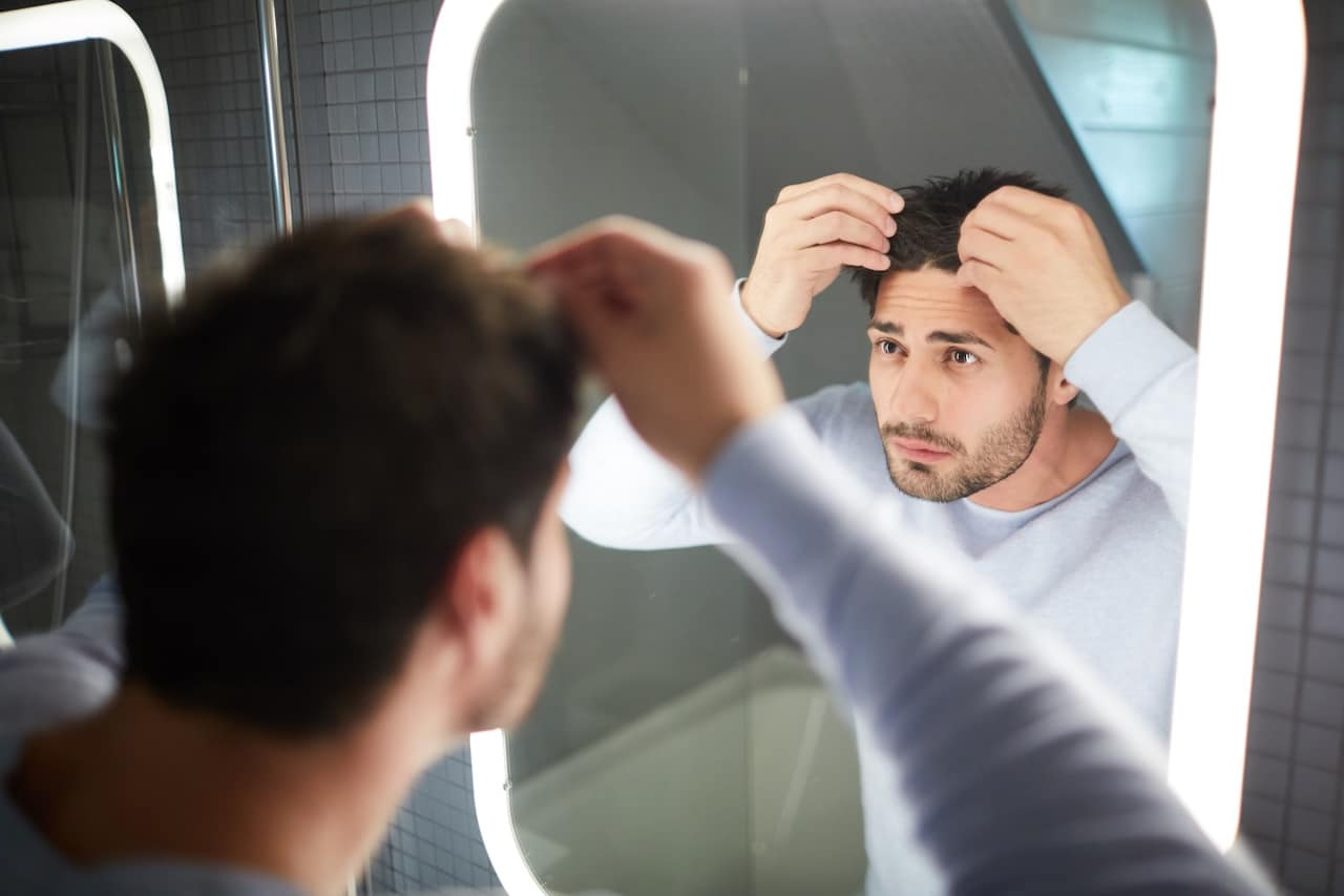 Man checking his hair in the mirror