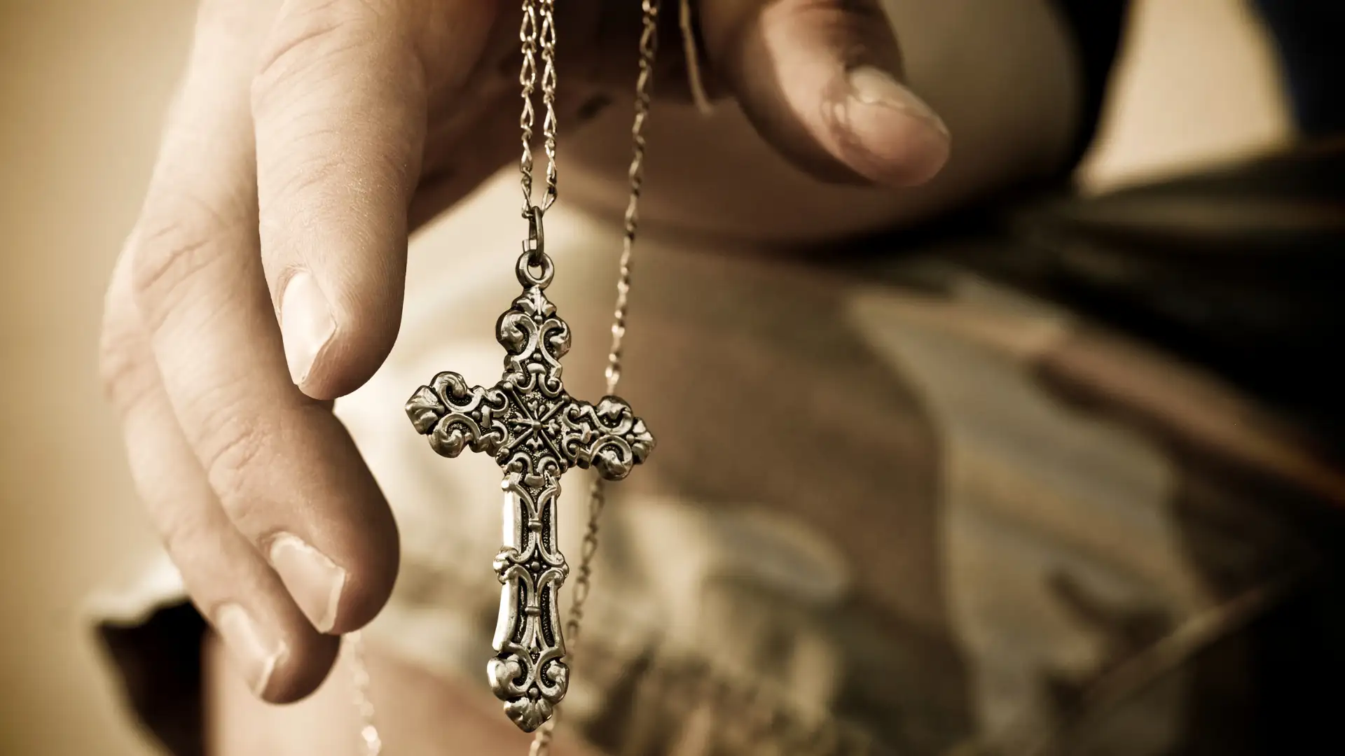 Hand holding a white gold cross pendant and necklace | Christian Jewelry | Glor-e