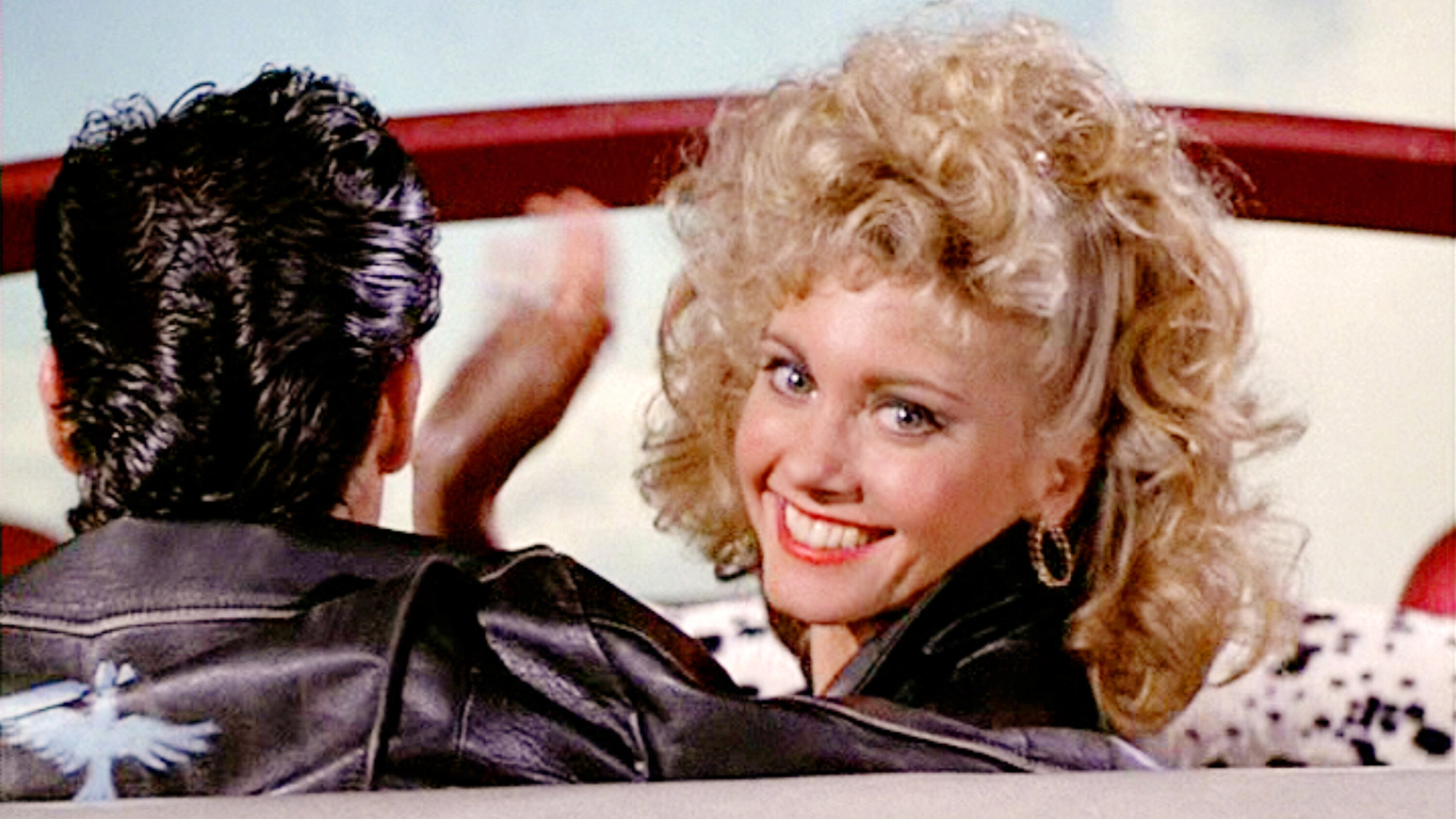 Olivia Newton-John waving goodbye at the end of Grease.