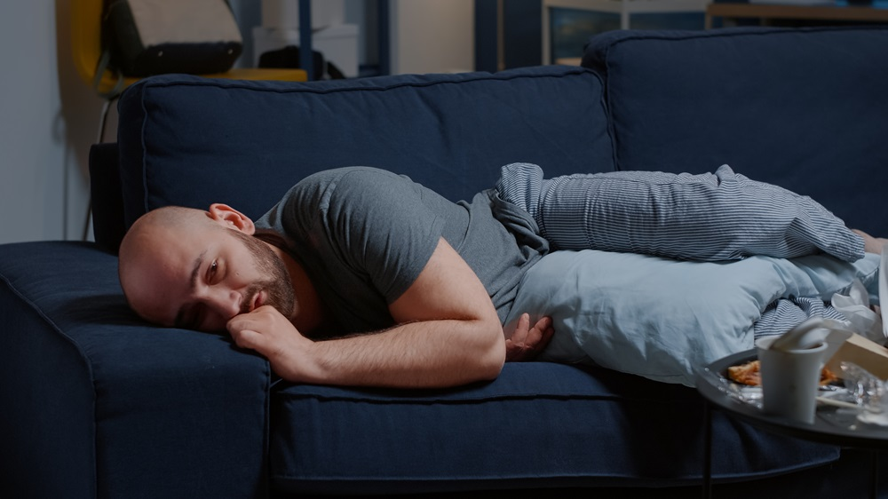 bald man emotional while lying on a couch