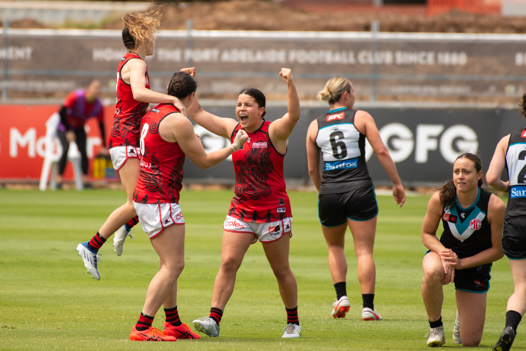 Georgia Gee, Bonnie Toogood, and Maddy Prespakis celebrate a Toogood goal against Port Adelaide during Season Seven. Photo: Dani Brown.