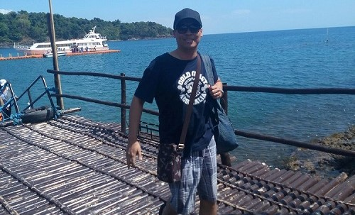 bald guy wearing sunglasses and a baseball cap in a beach resort