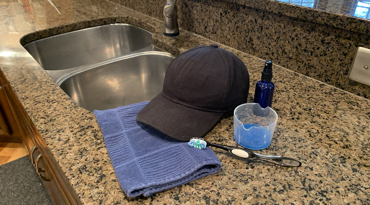 A person washing a hat in a sink