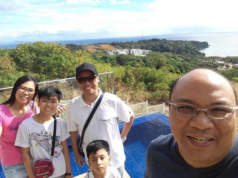 bald guy wearing a baseball cap while touring a family looking at beach properties