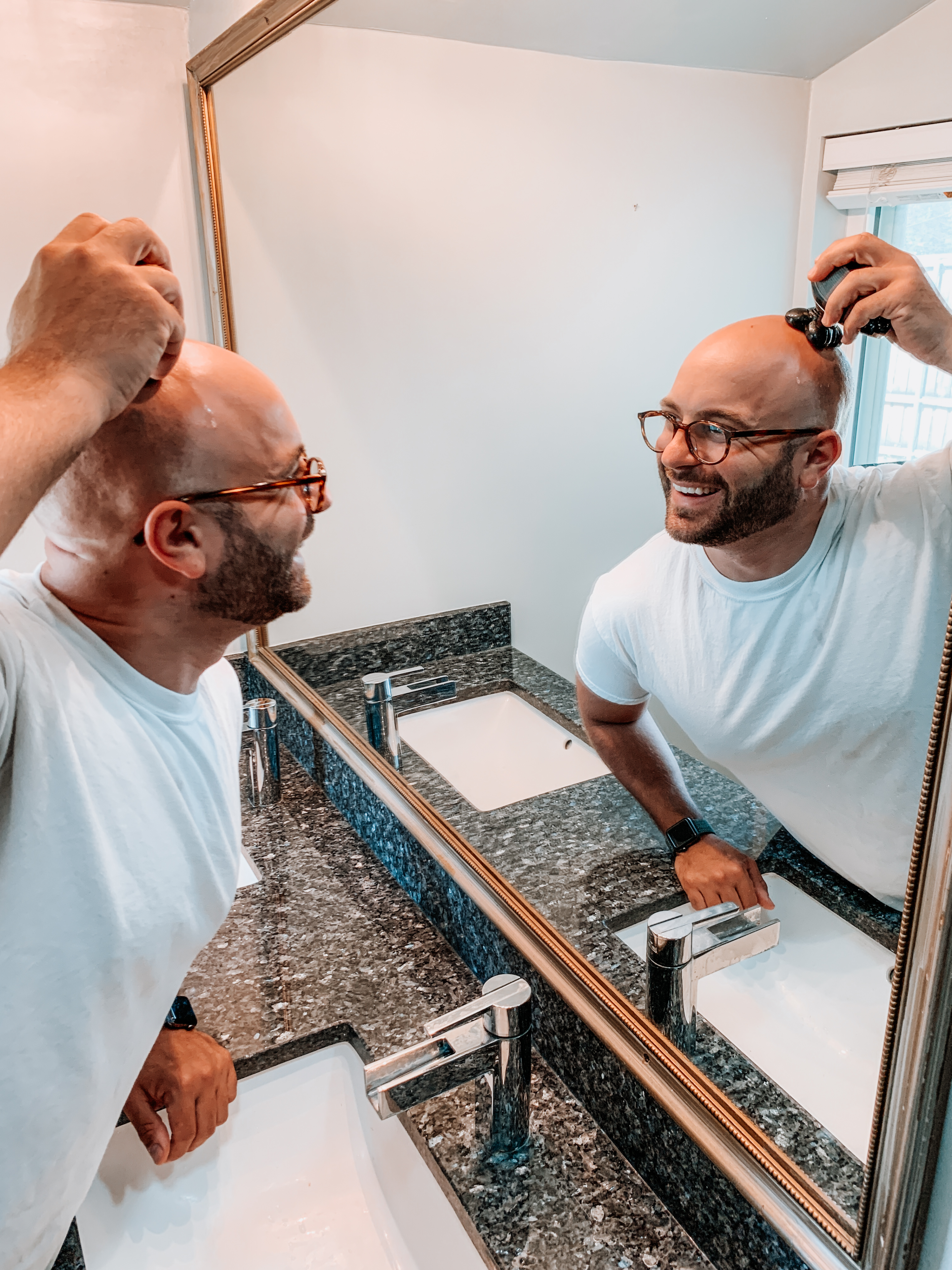 bald man shaving his head with a rotary shaver