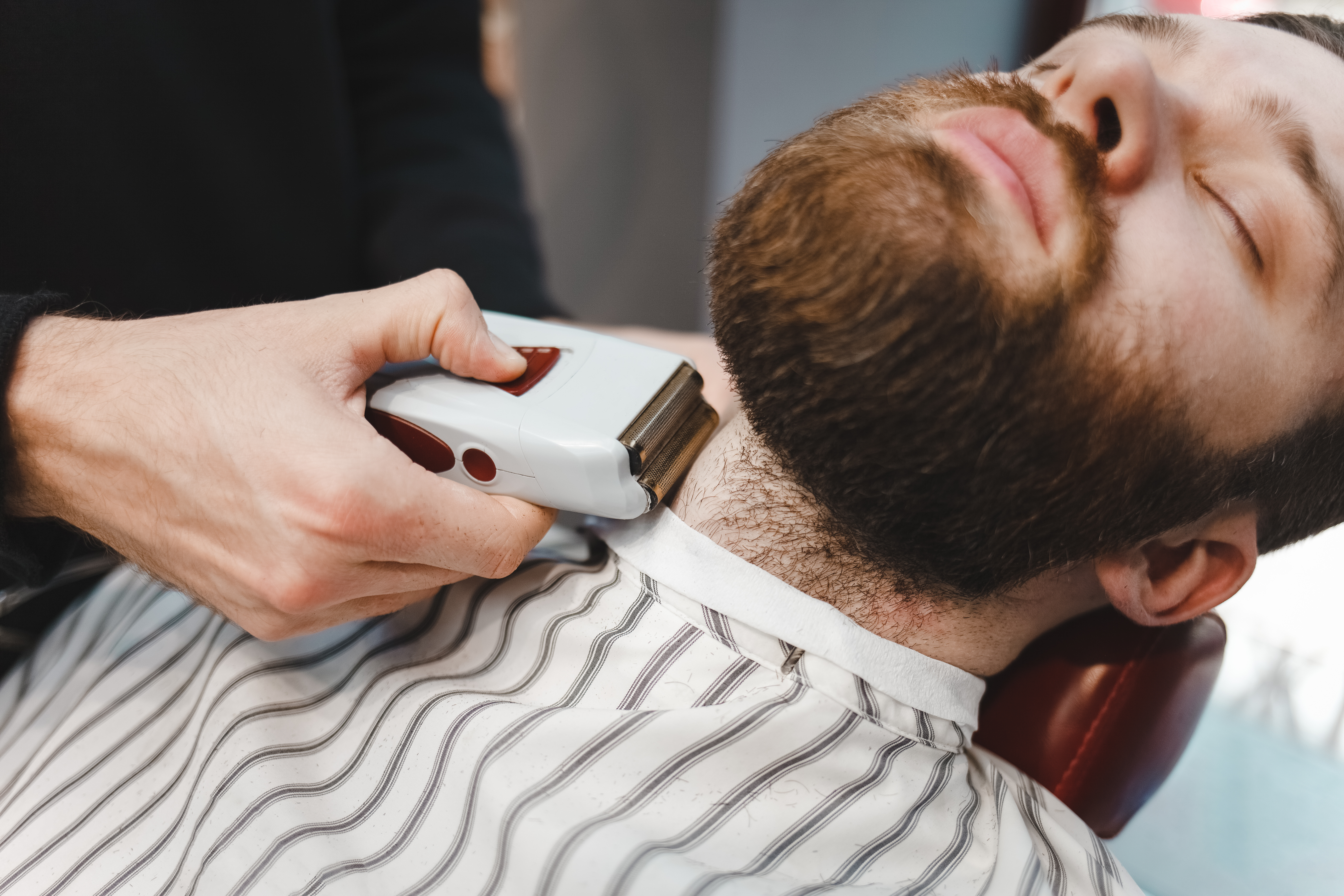 photo of bearded man getting a shave using a foil shaver